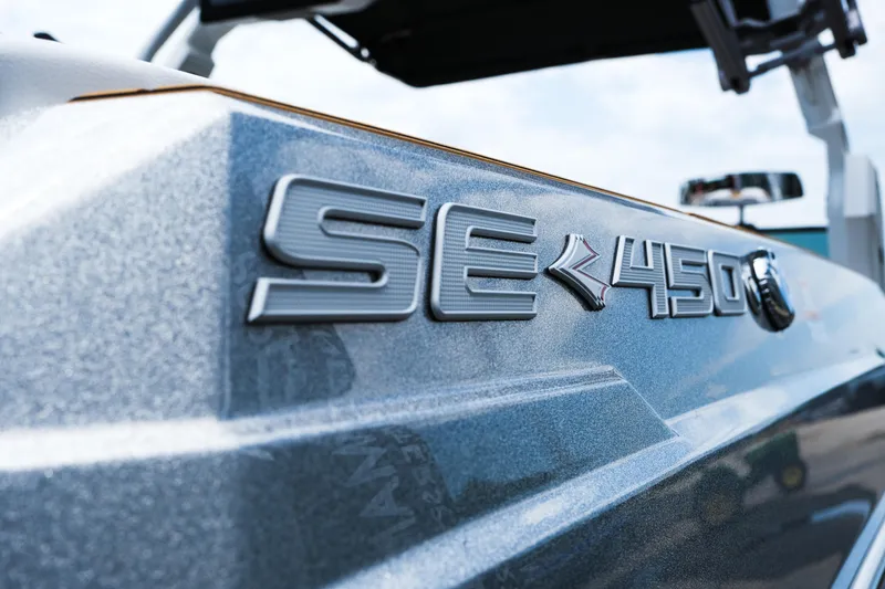 Slide: The Image of 2025 Supra SE450 boat close-up, showcasing sleek metallic design and model emblem. - 12