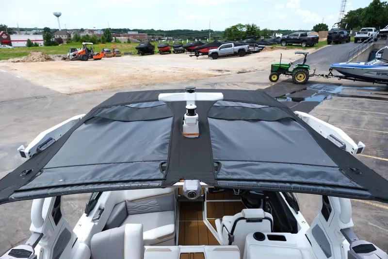 Slide: The Image of 2025 Supra SE450 boat with open canopy, parked in a marina. - 28