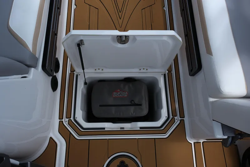 Slide: The Image of 2025 Supra SE450 boat storage compartment with branded bag on stylish deck. - 30