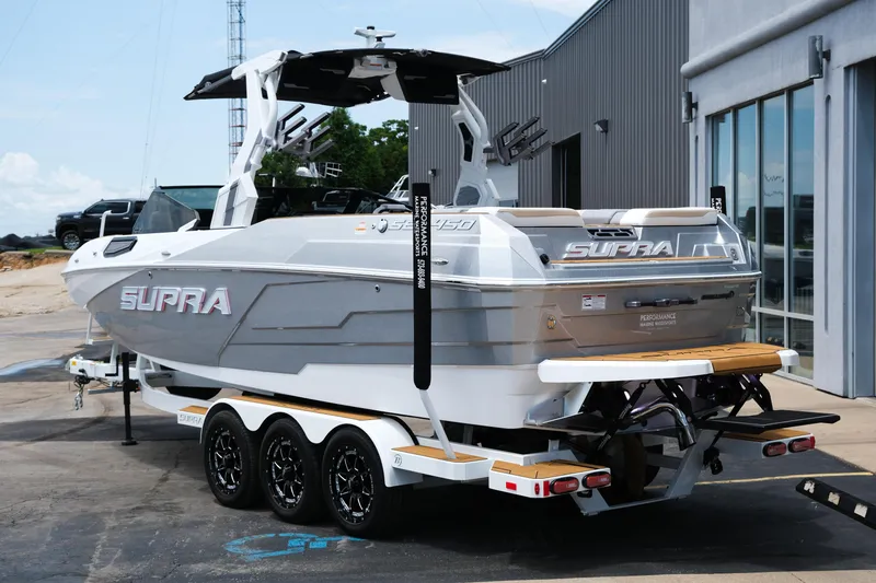 Slide: The Image of 2025 Supra SE450 boat on trailer, parked outside a modern building. - 4
