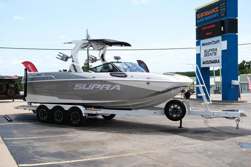 Slide: The Image of 2025 Supra SE450 boat on trailer at dealership, showcasing sleek design and modern features. - 8