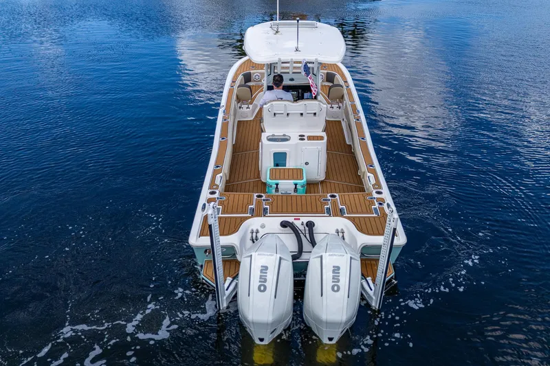 Slide: The Image of 2023 Tidewater 2700 Carolina Bay boat on water, featuring dual outboard engines. - 13