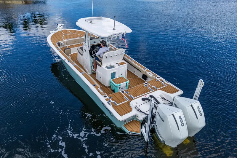 Slide: The Image of 2023 Tidewater 2700 Carolina Bay boat on water, featuring dual Mercury engines. - 14