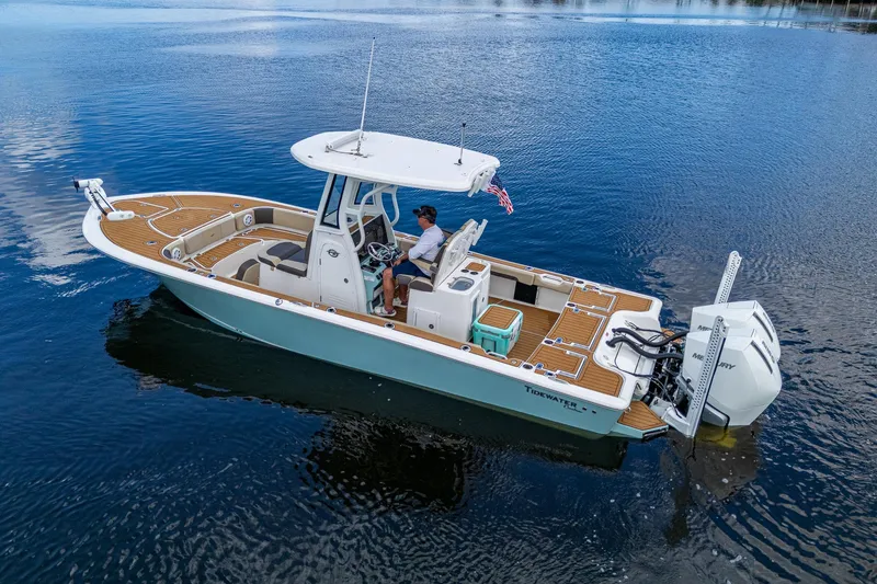 Slide: The Image of 2023 Tidewater 2700 Carolina Bay boat on calm water, featuring modern design and dual engines. - 16