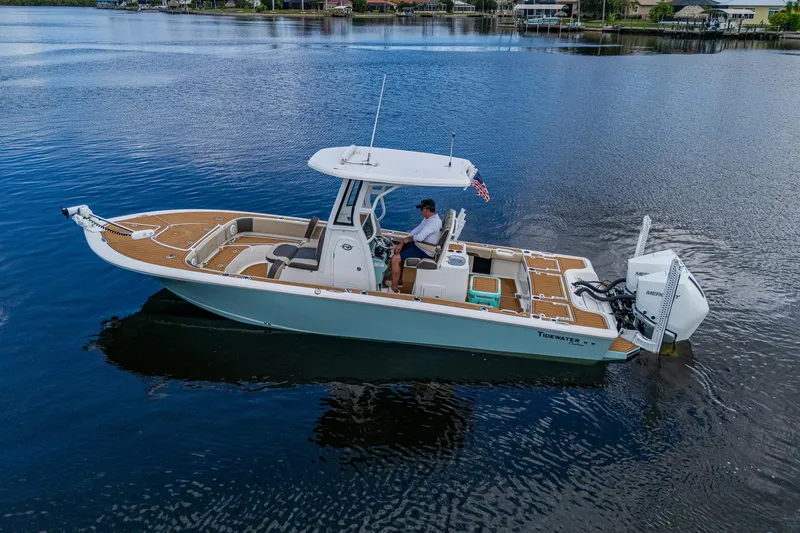 Slide: The Image of 2023 Tidewater 2700 Carolina Bay boat on calm water, featuring modern design and spacious deck. - 17