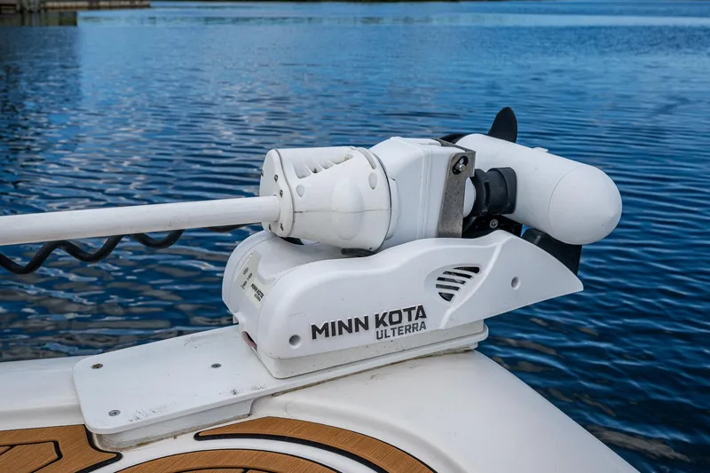 Slide: The Image of Minn Kota Ulterra motor on 2023 Tidewater 2700 Carolina Bay boat, docked on calm water. - 22