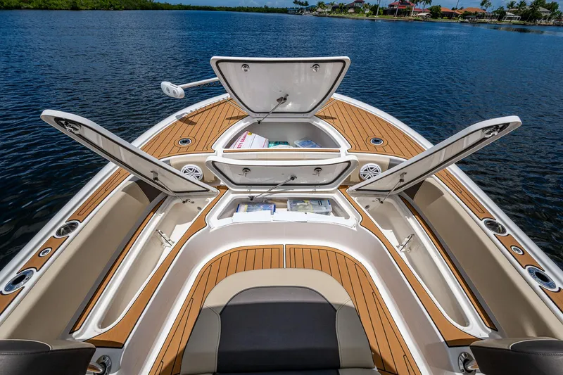 Slide: The Image of 2023 Tidewater 2700 Carolina Bay boat with open storage compartments on a calm lake. - 26