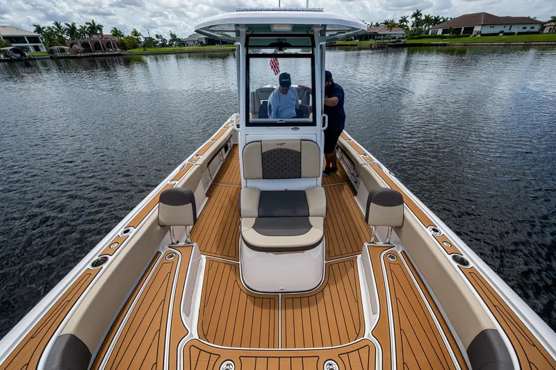 Slide: The Image of 2023 Tidewater 2700 Carolina Bay boat on calm water, featuring spacious deck and seating. - 29