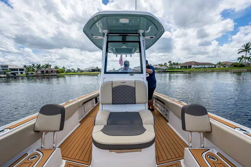 Slide: The Image of 2023 Tidewater 2700 Carolina Bay boat on a scenic waterway under a cloudy sky. - 30