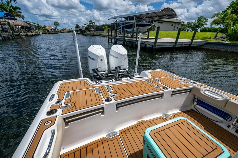 Slide: The Image of 2023 Tidewater 2700 Carolina Bay boat with dual Mercury engines on a sunny waterway. - 32