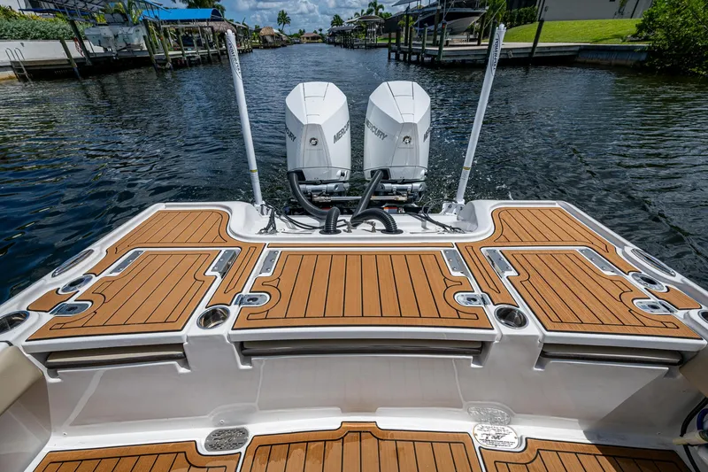 Slide: The Image of 2023 Tidewater 2700 Carolina Bay boat with dual Mercury engines on a calm waterway. - 33