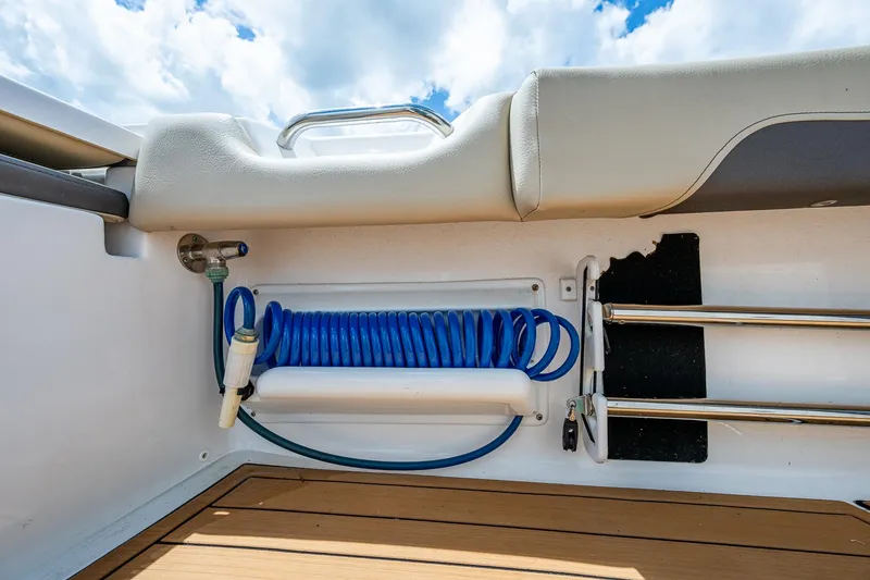 Slide: The Image of 2023 Tidewater 2700 Carolina Bay boat interior with coiled blue hose and ladder. - 35