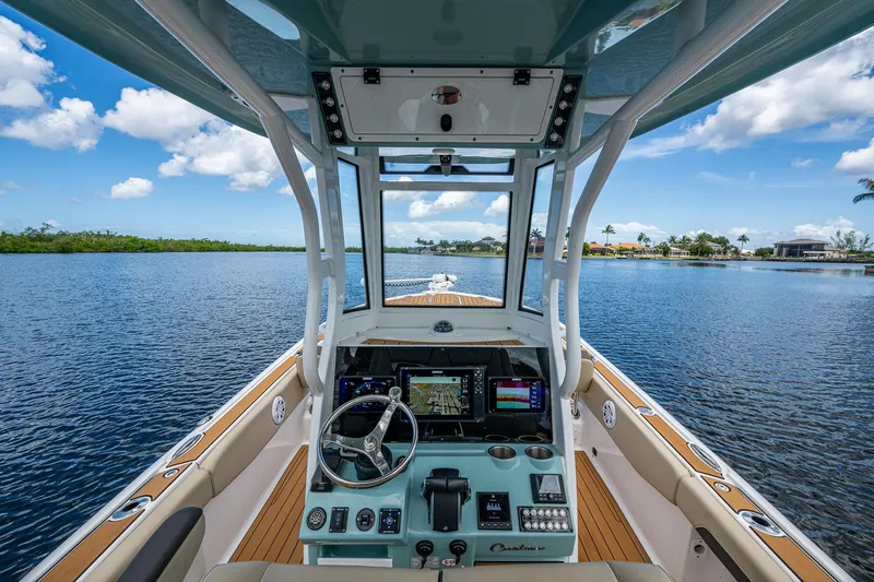 Slide: The Image of 2023 Tidewater 2700 Carolina Bay boat interior with advanced navigation system on a serene lake. - 45