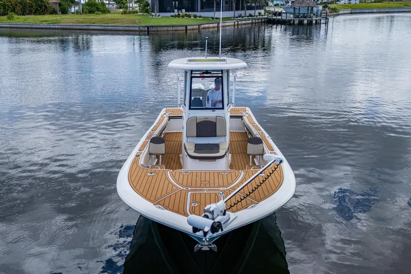 Slide: The Image of 2023 Tidewater 2700 Carolina Bay boat on calm water, featuring spacious deck and modern design. - 5