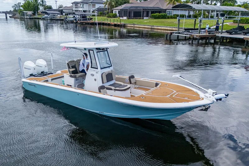 Slide: The Image of 2023 Tidewater 2700 Carolina Bay boat on calm water near residential docks. - 8