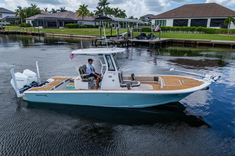 Slide: The Image of 2023 Tidewater 2700 Carolina Bay boat on calm water near residential docks. - 9