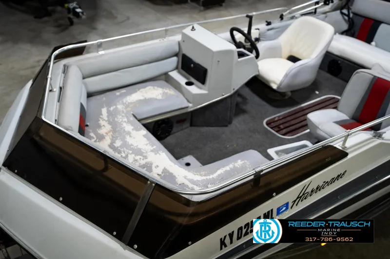 Slide: The Image of 1987 Hurricane 176 Deck Boat interior with seating and steering wheel, Reeder-Trausch Marine logo visible. - 12