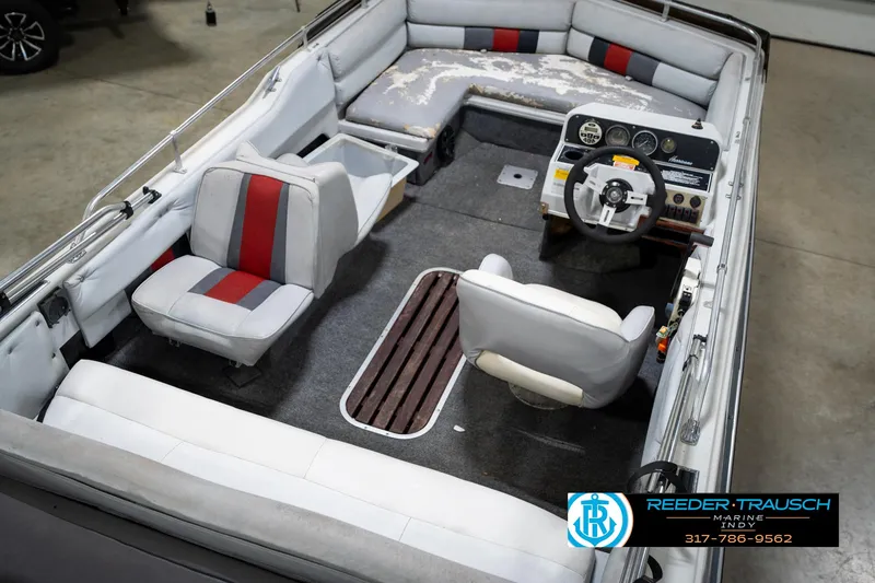 Slide: The Image of 1987 Hurricane 176 Deck Boat interior with red and gray seating, steering wheel, and dashboard. - 14