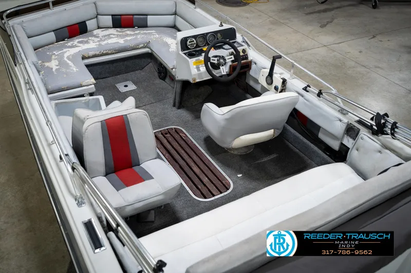 Slide: The Image of 1987 Hurricane 176 Deck Boat interior with seating and steering wheel, displayed in a showroom. - 15