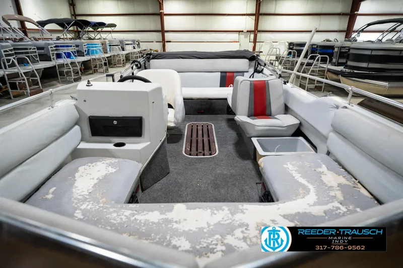 Slide: The Image of 1987 Hurricane 176 Deck Boat interior with worn seating, in a showroom. - 16