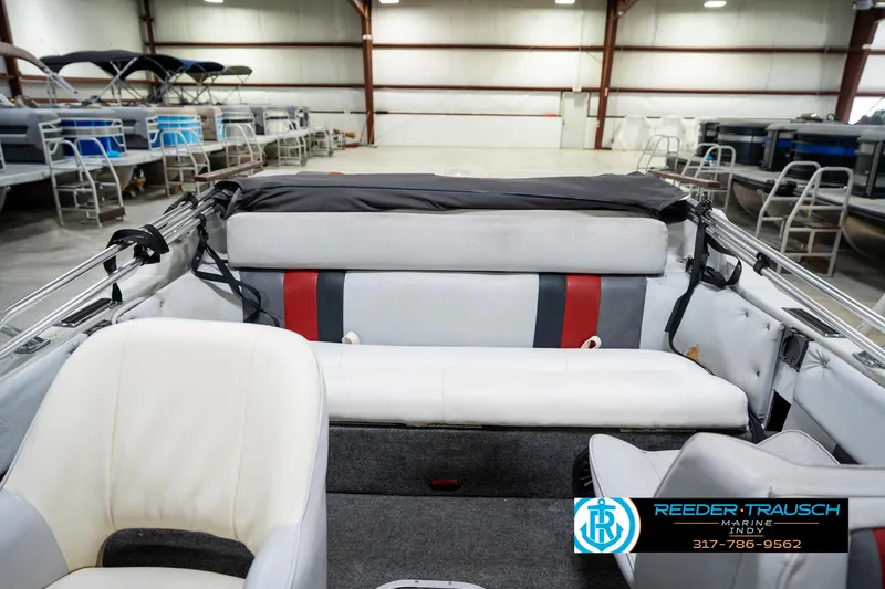 Slide: The Image of 1987 Hurricane 176 Deck Boat interior with white and red seating in a showroom. - 17