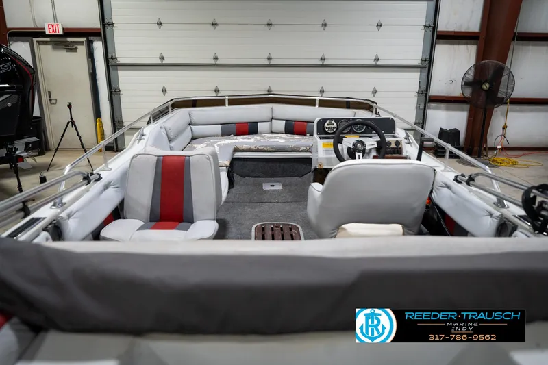 Slide: The Image of 1987 Hurricane 176 Deck Boat interior with gray and red seating in a garage setting. - 18