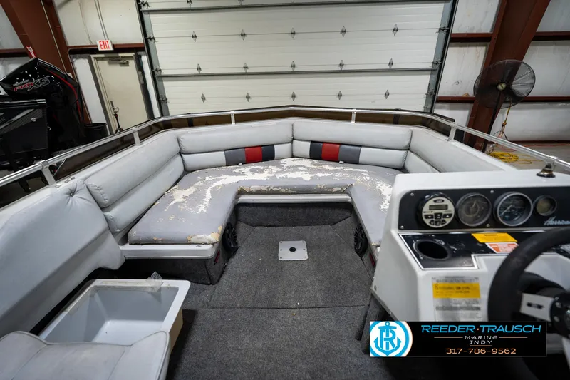 Slide: The Image of 1987 Hurricane 176 Deck Boat interior with worn seating and control panel in a garage setting. - 19
