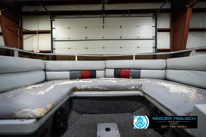 Slide: The Image of 1987 Hurricane 176 Deck Boat interior with worn seating in a garage setting. - 20