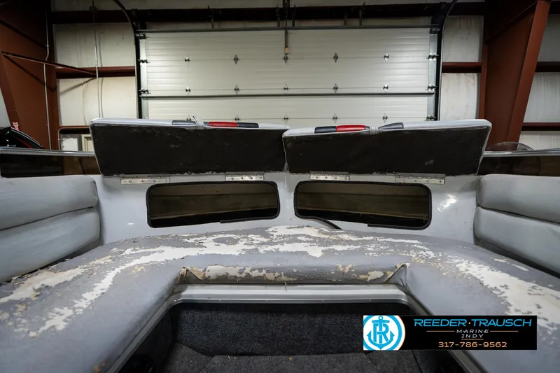Slide: The Image of 1987 Hurricane 176 Deck Boat interior with worn seating in a garage setting. - 21
