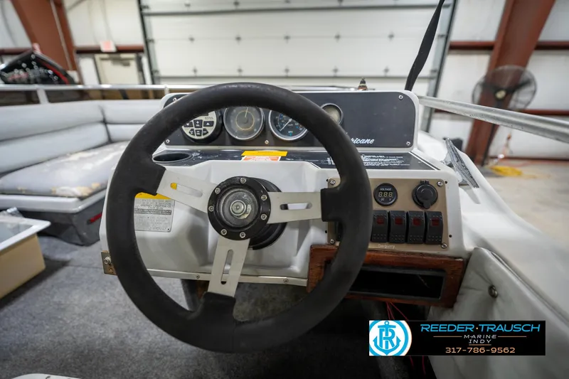 Slide: The Image of 1987 Hurricane 176 Deck Boat steering wheel and dashboard in a garage setting. - 26