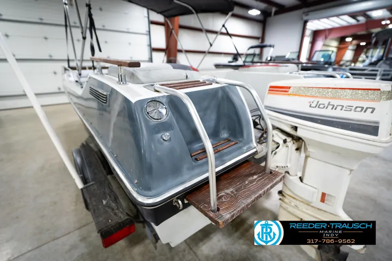 Slide: The Image of 1987 Hurricane 176 Deck Boat with Johnson outboard motor in indoor storage. - 33