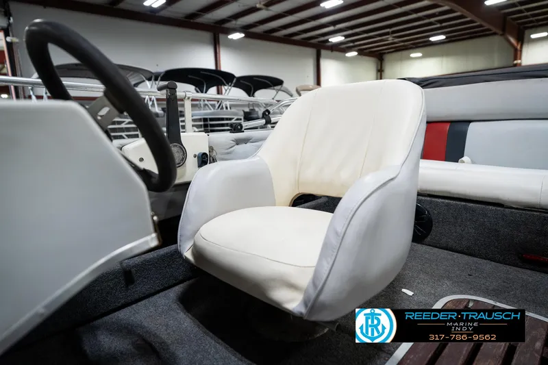 Slide: The Image of 1987 Hurricane 176 Deck Boat interior with white captain's chair in a showroom. - 38