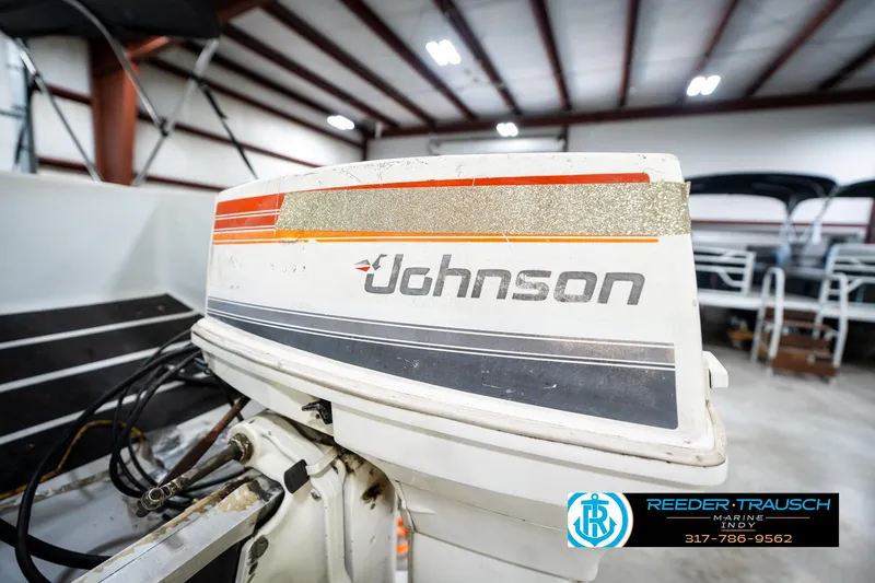 Slide: The Image of 1987 Hurricane 176 Deck Boat with Johnson outboard motor in a showroom. - 40