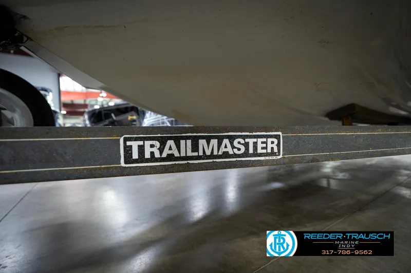 Slide: The Image of 1987 Hurricane 176 Deck Boat on Trailmaster trailer in showroom, Reeder Trausch Marine logo visible. - 45