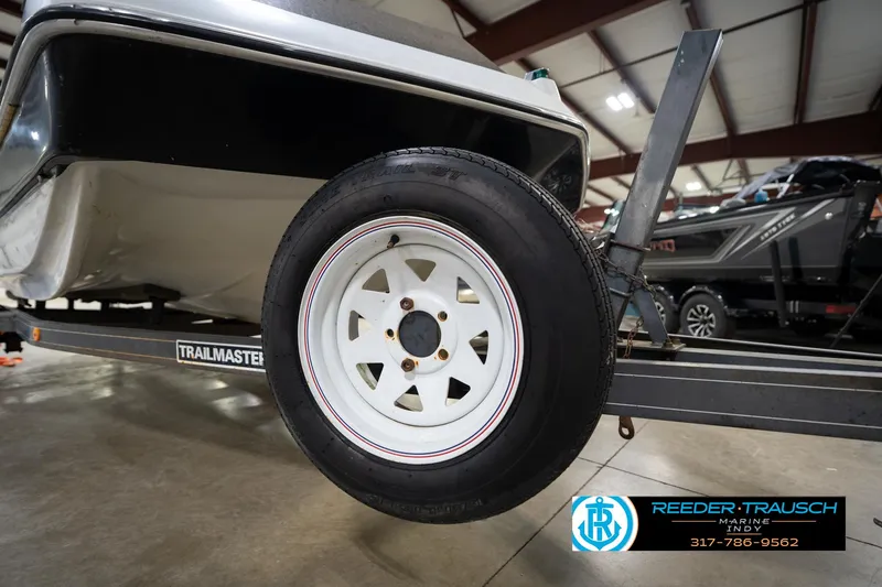 Slide: The Image of 1987 Hurricane 176 Deck Boat on a Trailmaster trailer in a showroom. - 46