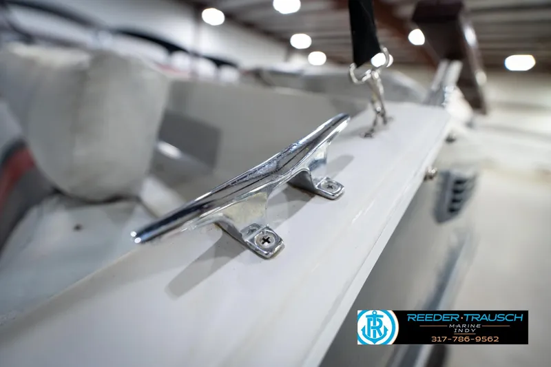 Slide: The Image of 1987 Hurricane 176 Deck Boat cleat detail in indoor showroom, Reeder-Trausch Marine logo visible. - 47