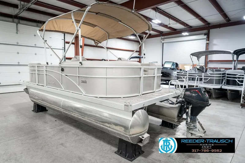 Slide: The Image of 2018 Bennington 20 SSRX pontoon boat in indoor showroom with canopy and motor. - 10