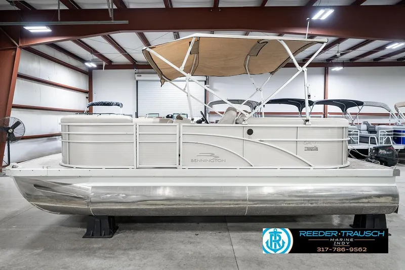 Slide: The Image of 2018 Bennington 20 SSRX pontoon boat in showroom with canopy and logo. - 11