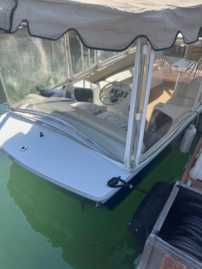 Slide: The Image of 1994 Duffy Classic 21 boat docked, featuring a covered seating area and steering wheel. - 3