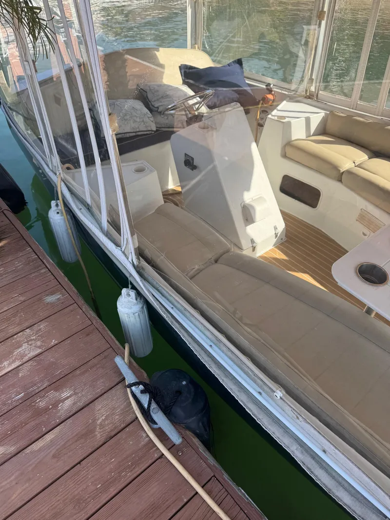 Slide: The Image of 1994 Duffy Classic 21 boat docked, featuring beige seating and clear canopy. - 5