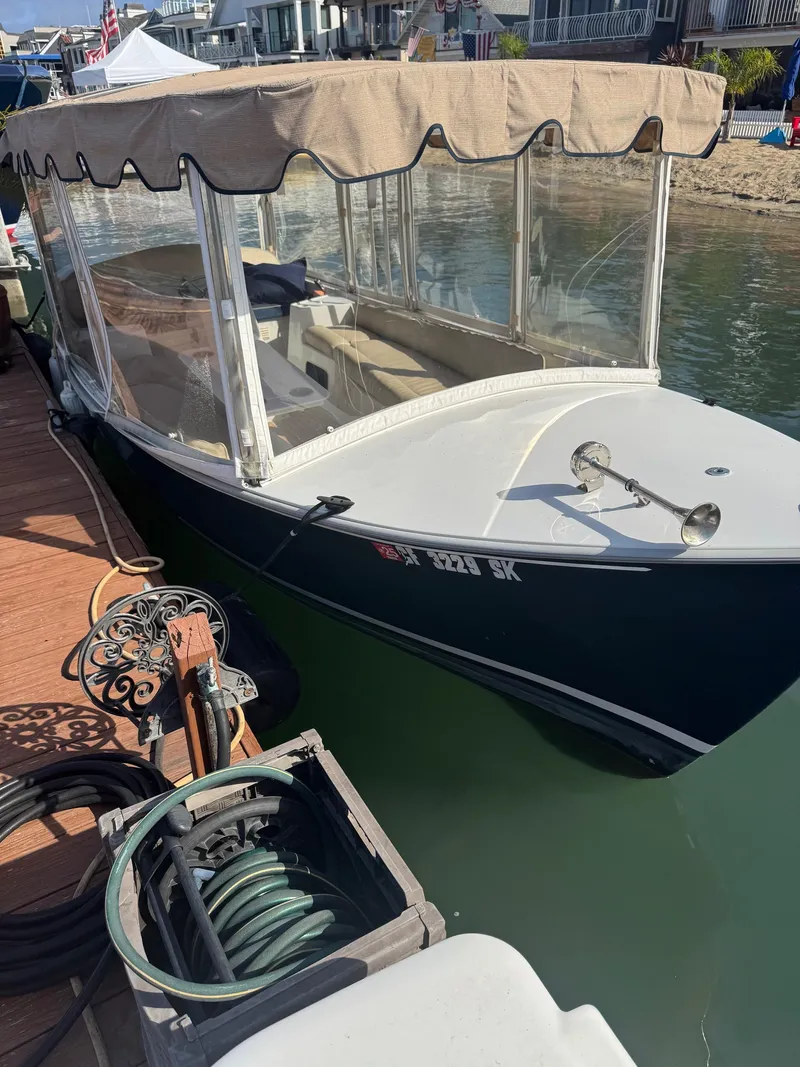 Slide: The Image of 1994 Duffy Classic 21 boat docked, featuring a beige canopy and clear side panels. - 6