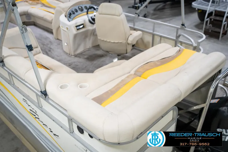 Slide: The Image of 2005 Bennington 2050 boat interior with beige seating and dashboard, featuring cup holders. - 14