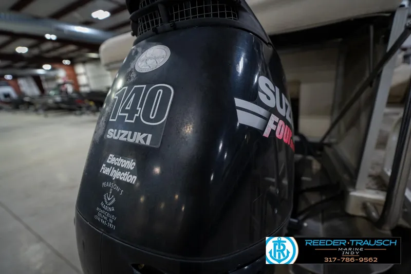 Slide: The Image of Suzuki 140 outboard motor on a 2005 Bennington 2050 boat in a showroom. - 19