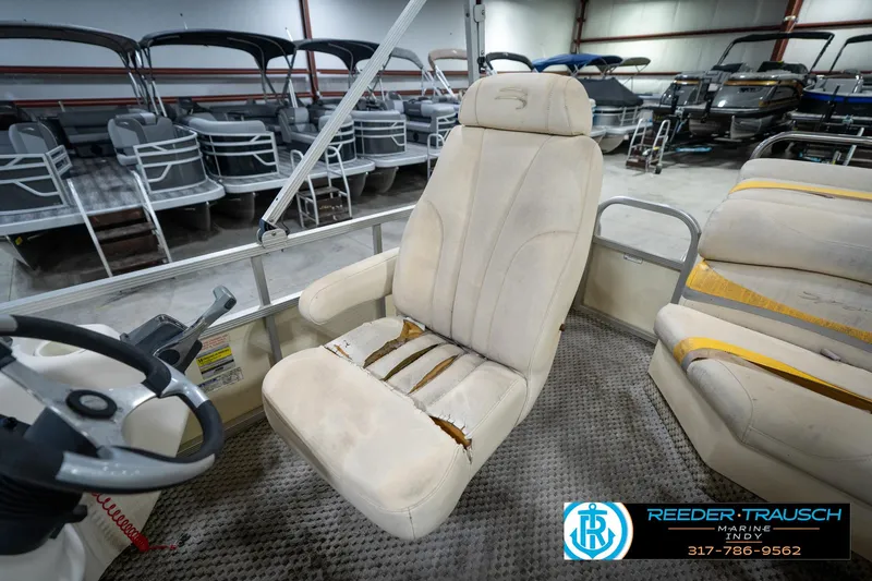 Slide: The Image of 2005 Bennington 2050 boat interior with worn captain's chair and steering wheel in showroom. - 31