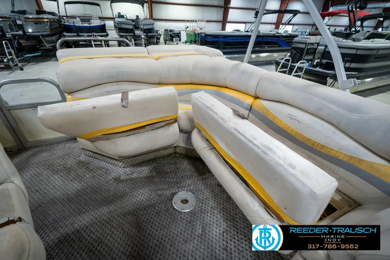 Slide: The Image of 2005 Bennington 2050 pontoon boat interior with worn seating in a showroom. - 37