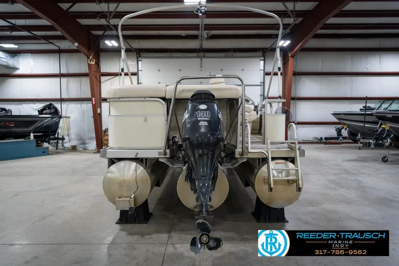 Slide: The Image of 2005 Bennington 2050 pontoon boat in indoor storage with outboard motor. - 7