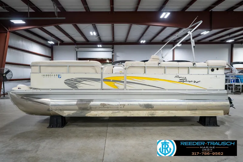 Slide: The Image of 2005 Bennington 2050 pontoon boat in warehouse, side view with yellow and gray graphics. - 9
