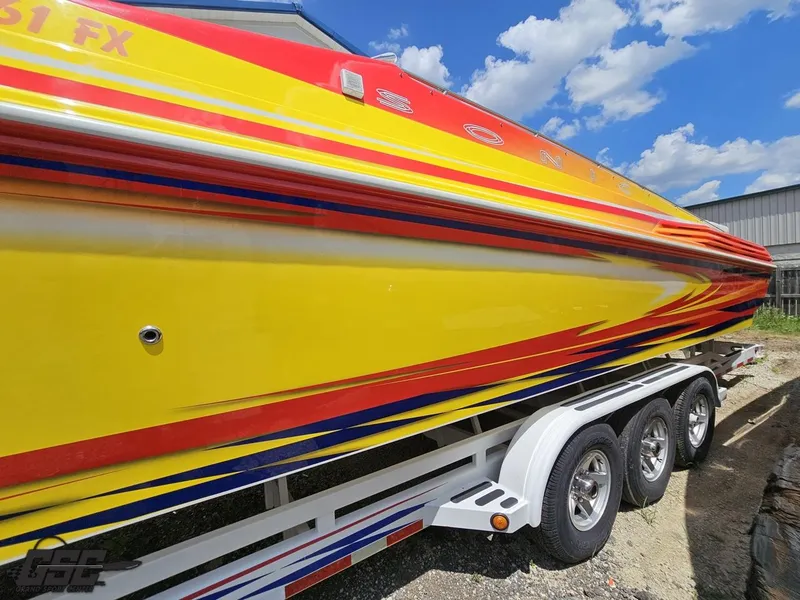 Slide: The Image of Brightly colored 2004 Sonic USA 45SS speedboat on trailer under blue sky. - 22