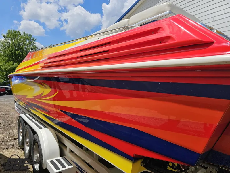 Slide: The Image of Colorful 2004 Sonic USA 45SS speedboat with vibrant stripes under a blue sky. - 25