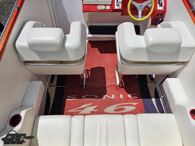 Slide: The Image of Interior of a 2004 Sonic USA 45SS boat with white seating and red accents. - 39
